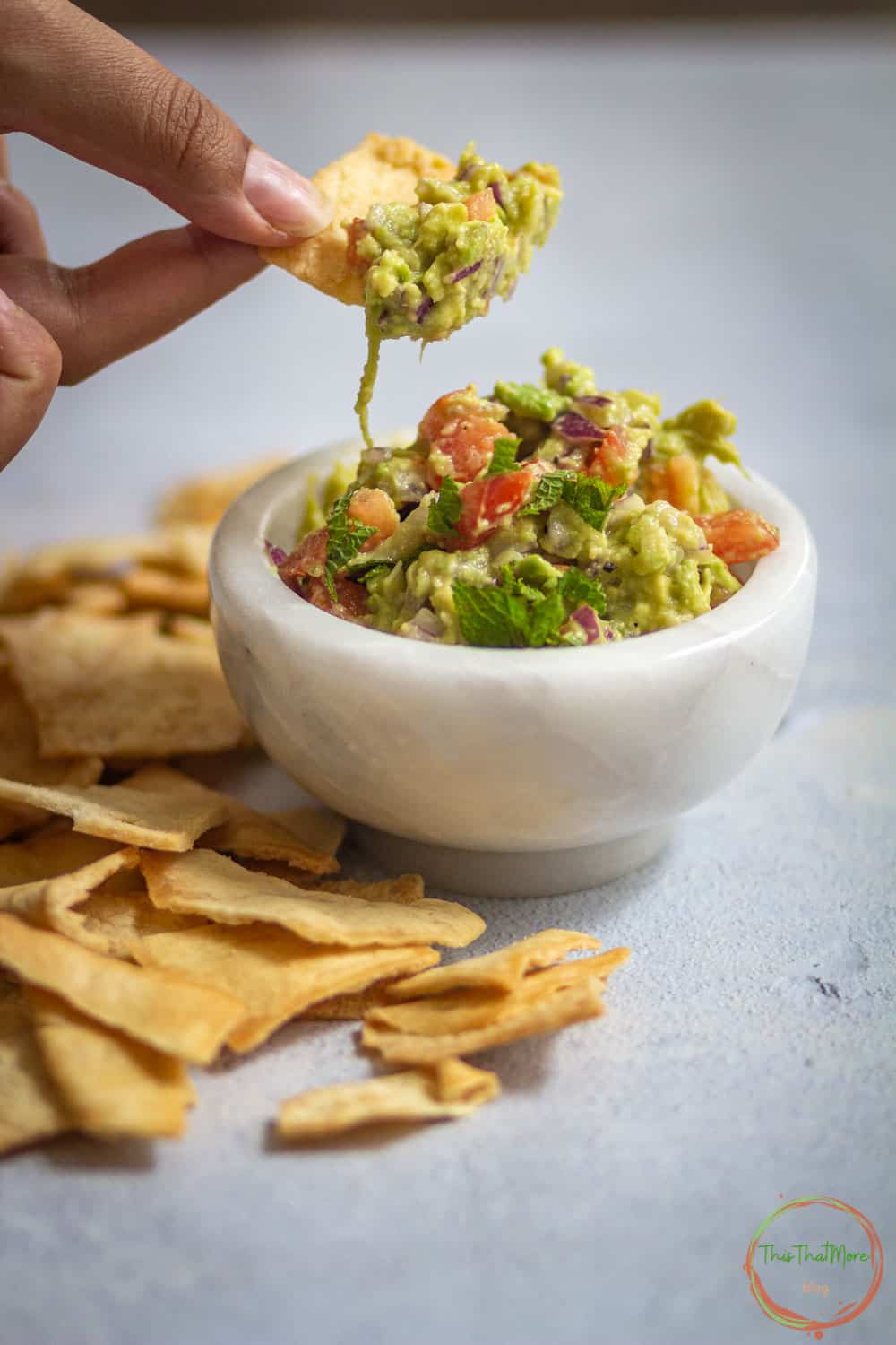 Taking a bite of guacamole in cracers.