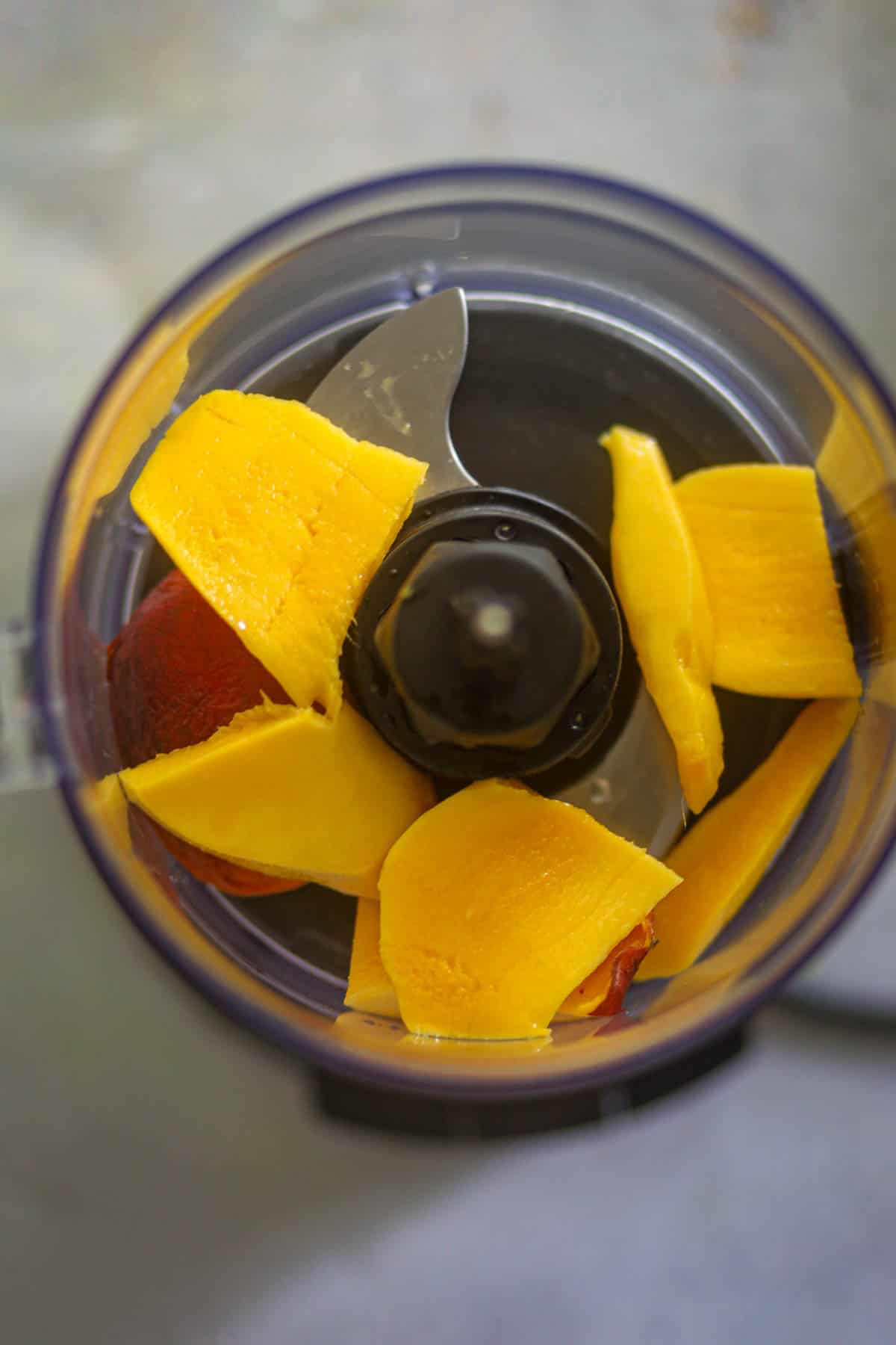 add peaches, mangoes,a nd water in the blender.