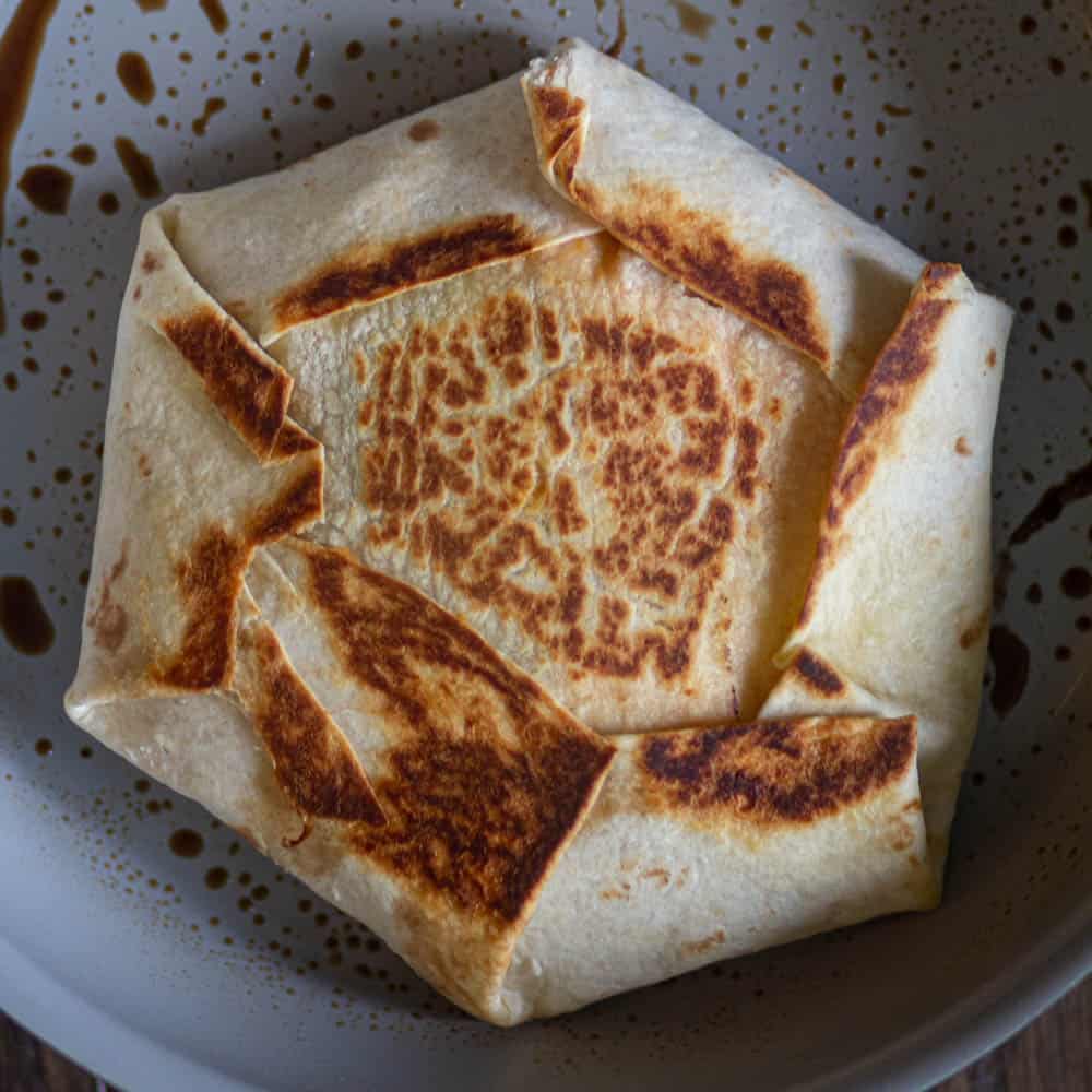 once on eside is cooked, flip the crunchwrap until golden brown