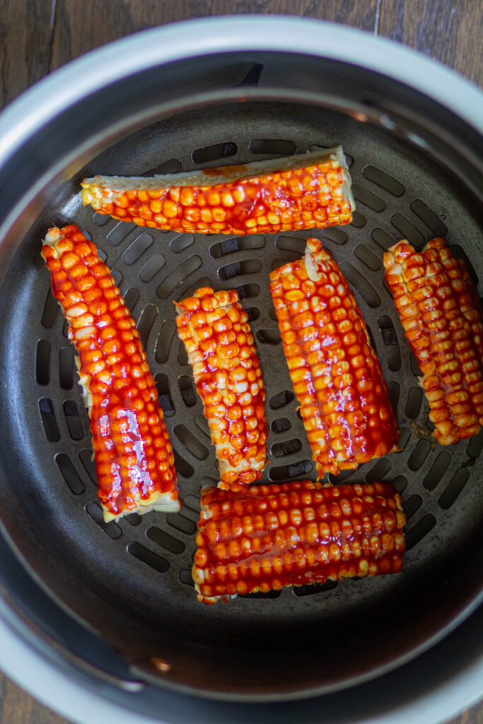 place the corn ribs in the air fryer basket and spray some oil
