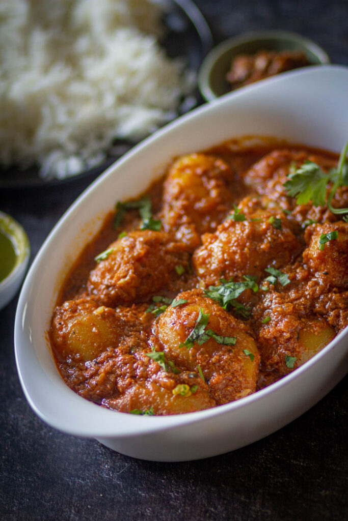dum aloo recipe in white bowl coated with masala