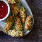 air fryer jalapeno poppers on a white plate & served with sauce