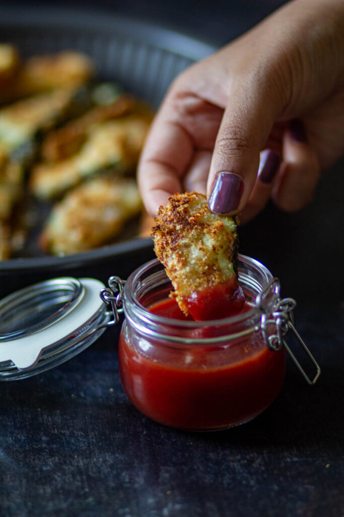 dipping the zucchini fries in the ketchup