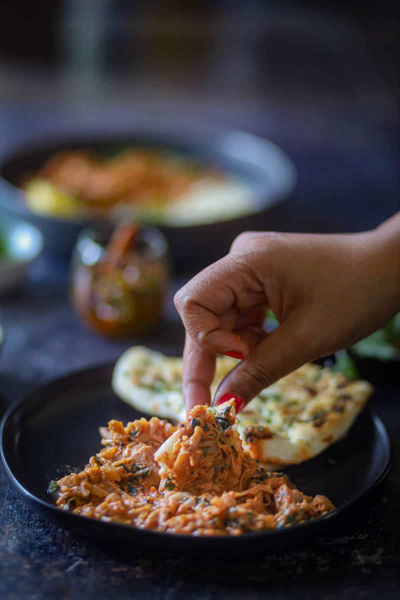 Taking a bite of jackfruit curry with naan.
