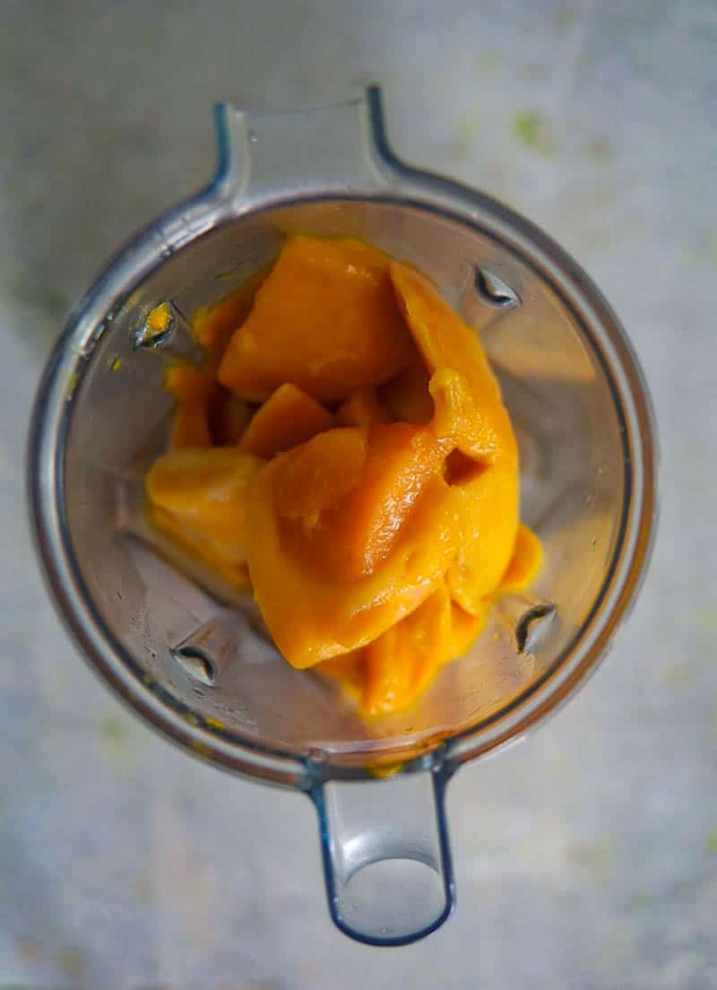 Add mango and coconut water in a blender.