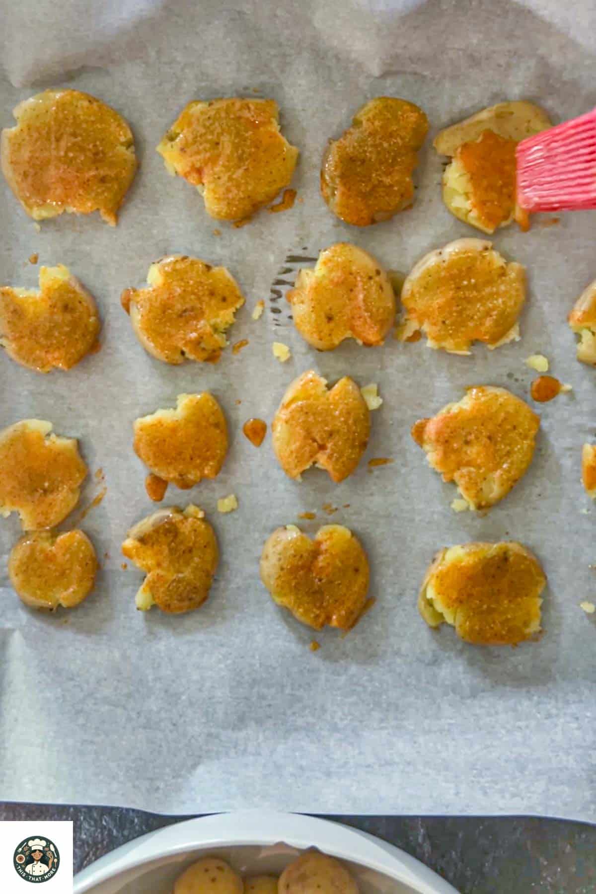 Brush spiced oil mix over the smash potatoes and bake them until crisp.